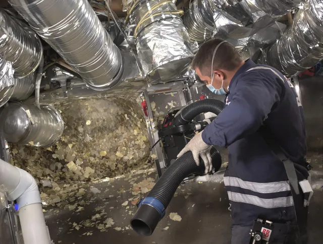 Bedford Air Duct Cleaning specialist operating negative pressure cleaning equipment for thorough duct maintenance in Bedford